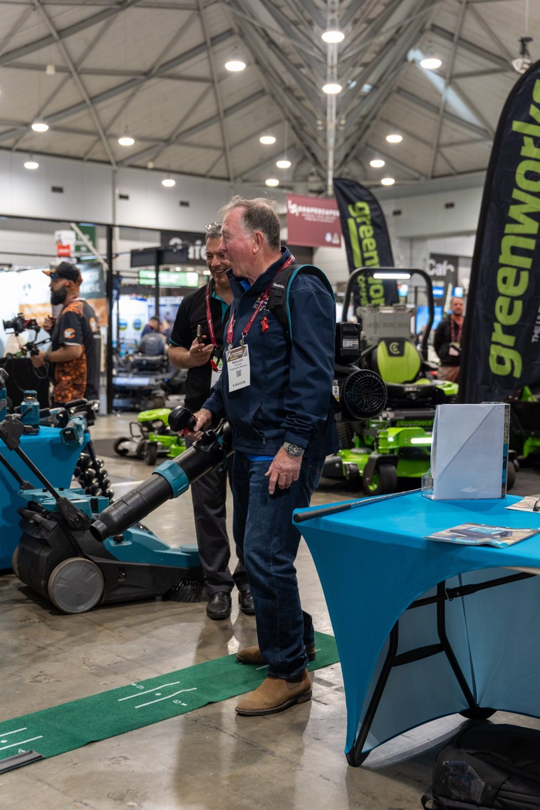 Visitor trying a backpack blower at an exhibitor stand