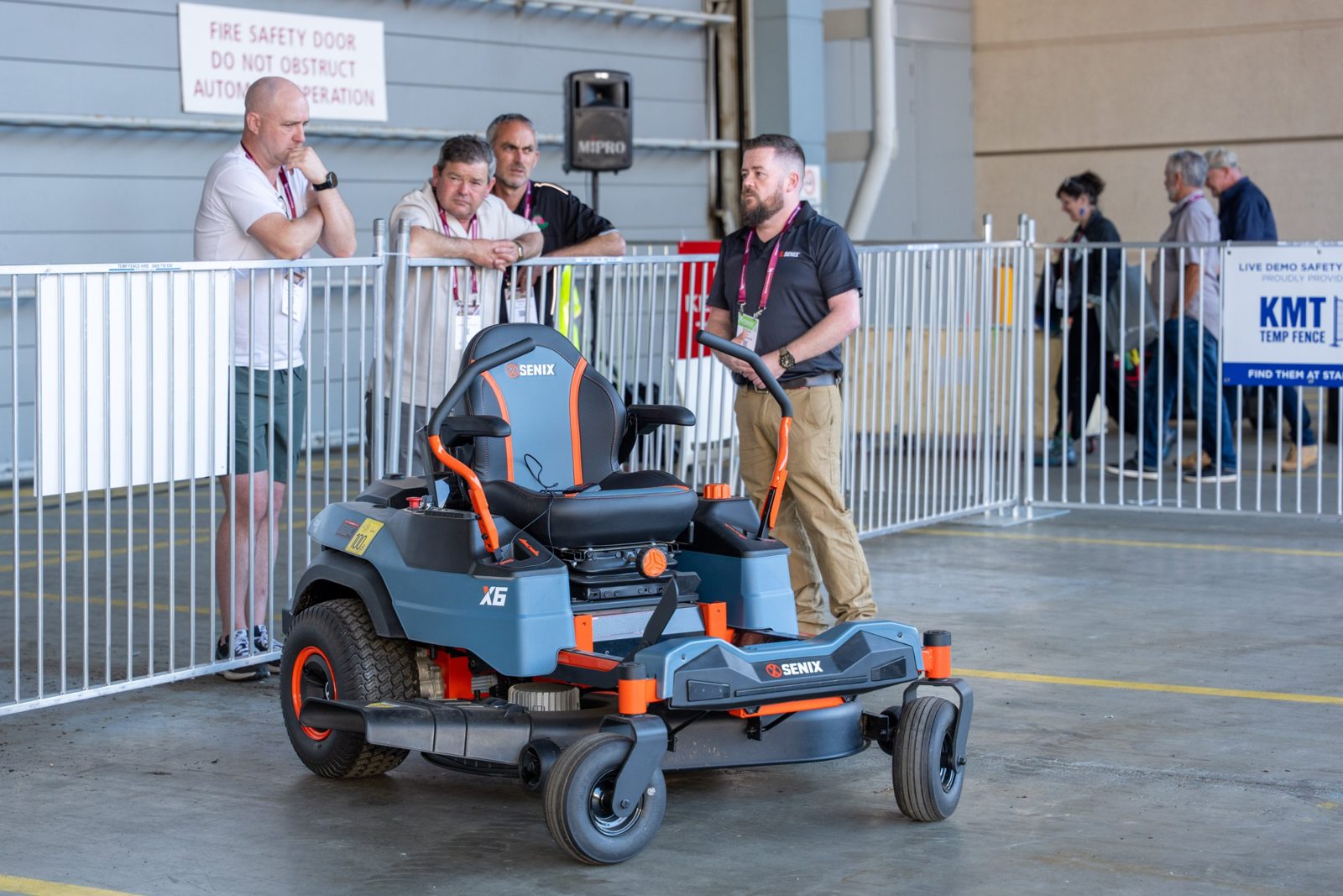 Visitors watching a ride-on mower demonstration