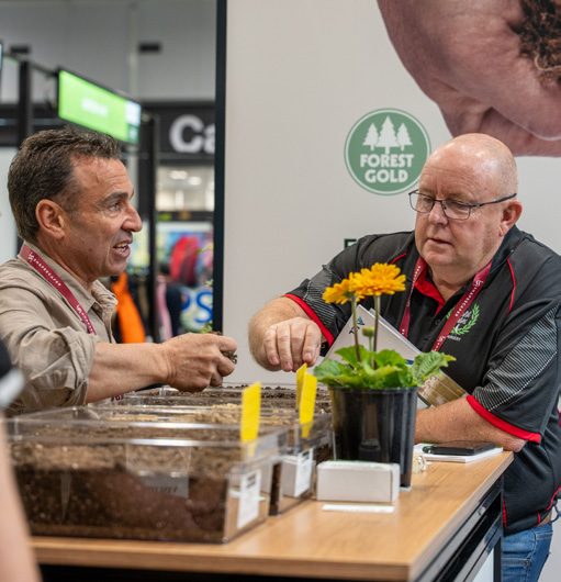 Exhibitor showing a plant product to a visitor