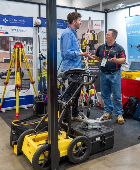 Visitors discussing equipment at a stand